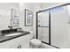 Bright bathroom features a sleek vanity with a dark countertop, and a modern glass-enclosed shower at 5009 Duval Cir, Tega Cay, SC 29708