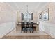 Elegant dining room featuring wainscoting, decorative wallpaper, and a stylish chandelier at 5009 Duval Cir, Tega Cay, SC 29708