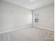A bright bedroom with neutral carpeting and a window with a view at 5013 Duval Cir, Tega Cay, SC 29708