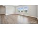 Sunlit living area features sleek flooring, neutral walls, and an abundance of natural light from three windows at 5013 Duval Cir, Tega Cay, SC 29708