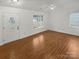 Open living room featuring beautiful hardwood flooring, white walls, a ceiling fan, and natural light at 5134 Possum Trot Ln, Charlotte, NC 28215