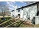 Back exterior of home with a patio, spacious yard, and the exterior white brick elevation at 523 Belmorrow Dr, Charlotte, NC 28214