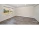 Bright bedroom featuring a large window, neutral walls and stylish gray wood-look flooring at 523 Belmorrow Dr, Charlotte, NC 28214