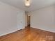 Bedroom featuring hardwood floors, a light fixture, and a doorway leading to the hallway at 5300 Buckingham Dr, Charlotte, NC 28209