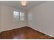 Bedroom with hardwood floors, a large window, and a light fixture that adds a touch of elegance at 5300 Buckingham Dr, Charlotte, NC 28209