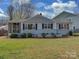 Charming single-story home features a well-manicured lawn, classic shutters, and a screened in porch at 5300 Buckingham Dr, Charlotte, NC 28209