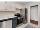 Bright kitchen featuring stainless steel appliances, gray cabinets, white countertops and tile floor at 5300 Buckingham Dr, Charlotte, NC 28209