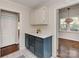 Bright kitchenette with white countertops, painted cabinets, and easy access to a closet and another room at 5300 Buckingham Dr, Charlotte, NC 28209