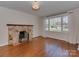 Comfortable living room featuring hardwood floors, a stone fireplace, and large windows at 5300 Buckingham Dr, Charlotte, NC 28209