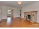 Open-concept living room featuring hardwood floors, stone fireplace, and seamless transition to other spaces at 5300 Buckingham Dr, Charlotte, NC 28209
