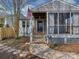 Charming screened porch entrance with a classic American flag, stone pathway, and tidy landscaping at 5300 Buckingham Dr, Charlotte, NC 28209
