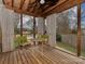 Charming screened porch with wooden furnishings and serene outdoor setting at 5300 Buckingham Dr, Charlotte, NC 28209