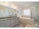 Bright bathroom featuring a soaker tub and walk-in shower, perfect for relaxation and convenience at 6187 Cloverdale Dr, Tega Cay, SC 29708