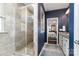 Beautiful bathroom featuring a stand up shower, stone floors, white cabinets and a granite countertop at 6187 Cloverdale Dr, Tega Cay, SC 29708