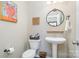 Powder bathroom with pedestal sink, decorative mirror and art, and a convenient toilet is stylish and functional at 6187 Cloverdale Dr, Tega Cay, SC 29708