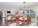 Open-concept dining area with hardwood floors, a chandelier, and a seamless transition to the living room at 6187 Cloverdale Dr, Tega Cay, SC 29708