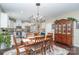 Elegant dining area featuring hardwood floors, a chandelier, and a view into the modern kitchen at 6187 Cloverdale Dr, Tega Cay, SC 29708