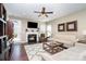 Cozy living room with a fireplace, hardwood floors, comfortable seating, and a ceiling fan at 6187 Cloverdale Dr, Tega Cay, SC 29708