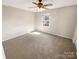 Cozy bedroom with neutral carpet, a ceiling fan, and a bright window providing natural light at 6436 Old Pineville Rd # C, Charlotte, NC 28217