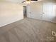 Spacious bedroom with neutral carpet, a ceiling fan, and two entry doors at 6436 Old Pineville Rd # C, Charlotte, NC 28217