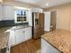 Bright kitchen featuring granite countertops, a stainless steel refrigerator, and ample cabinet space at 6436 Old Pineville Rd # C, Charlotte, NC 28217