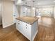 Open-concept kitchen with a granite island, wood floors, and views into the living area at 6436 Old Pineville Rd # C, Charlotte, NC 28217