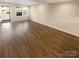 Spacious, empty living room showcasing new flooring and large windows at 6436 Old Pineville Rd # C, Charlotte, NC 28217