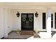 Close-up of double front doors adorned with wreaths, welcoming mat, and decorative lanterns at 7402 Henderson Park Rd, Huntersville, NC 28078