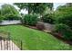 Well-manicured backyard with metal railing and privacy fence is perfect for entertaining and relaxing at 7924 Pemswood St, Charlotte, NC 28277