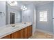 Light blue bathroom featuring double sinks, a mirror, and tiled flooring at 7924 Pemswood St, Charlotte, NC 28277
