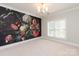 Bedroom with floral wallpaper accent wall, chandelier, and natural light from the window at 7924 Pemswood St, Charlotte, NC 28277