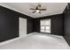 Bedroom with dark walls, light carpet, and a large window with shutters at 7924 Pemswood St, Charlotte, NC 28277