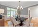 Elegant dining room featuring modern wallpaper, a stylish chandelier, and ample natural light at 7924 Pemswood St, Charlotte, NC 28277