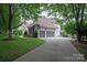 Home with a two-car garage surrounded by lush greenery and landscaping at 7924 Pemswood St, Charlotte, NC 28277