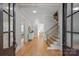 Inviting foyer with hardwood floors, staircase, and an open view into the living spaces at 7924 Pemswood St, Charlotte, NC 28277