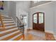 Bright foyer with hardwood floors, staircase, and arched entryway leading to the dining room at 7924 Pemswood St, Charlotte, NC 28277