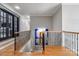 Hallway with wood stairs and iron railing leading to double doors at 7924 Pemswood St, Charlotte, NC 28277