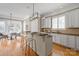 Open kitchen with breakfast bar, white cabinets, and hardwood floors flows into dining area at 7924 Pemswood St, Charlotte, NC 28277
