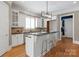 Well-lit kitchen featuring breakfast bar, white cabinetry, and stylish pendant lighting at 7924 Pemswood St, Charlotte, NC 28277