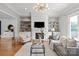 Cozy living room showcasing a modern fireplace, built-in bookshelves, and hardwood flooring at 7924 Pemswood St, Charlotte, NC 28277