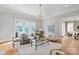Sunlit living room with hardwood floors, large windows, and a stylish chandelier at 7924 Pemswood St, Charlotte, NC 28277