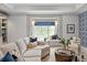 Bright living room with a large window seat, patterned wallpaper and modern furnishings at 7924 Pemswood St, Charlotte, NC 28277