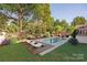 Inviting backyard pool with wooden deck and lounge chairs surrounded by lush landscaping at 7924 Pemswood St, Charlotte, NC 28277