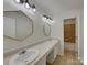 Bright bathroom features double vanity with decorative mirrors and a tiled shower/tub combination at 8103 Idlewild Rd, Indian Trail, NC 28079