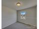 Neutral bedroom features modern trim, large window and carpeted floor at 8103 Idlewild Rd, Indian Trail, NC 28079