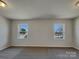 Empty main bedroom featuring carpeted floors, fresh white walls, and two windows with views of the neighborhood at 8103 Idlewild Rd, Indian Trail, NC 28079