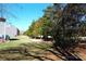 Expansive backyard featuring a grassy lawn, privacy trees, and mature landscaping at 8224 Golf Ridge Dr, Charlotte, NC 28277