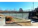 Full outdoor tennis court surrounded by a high chain-link fence for a secure and enjoyable recreational experience at 8224 Golf Ridge Dr, Charlotte, NC 28277