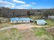 Aerial view of home with blue roof and detached garage surrounded by trees and open land at 836 Love Rd, Blackstock, SC 29014