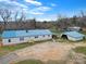 Charming home with a blue roof and a detached garage, set on a spacious lot with mature trees at 836 Love Rd, Blackstock, SC 29014